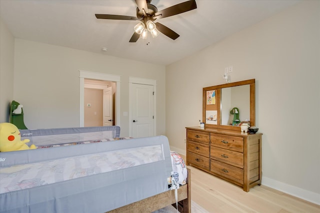 bedroom featuring baseboards, a ceiling fan, and light wood-type flooring