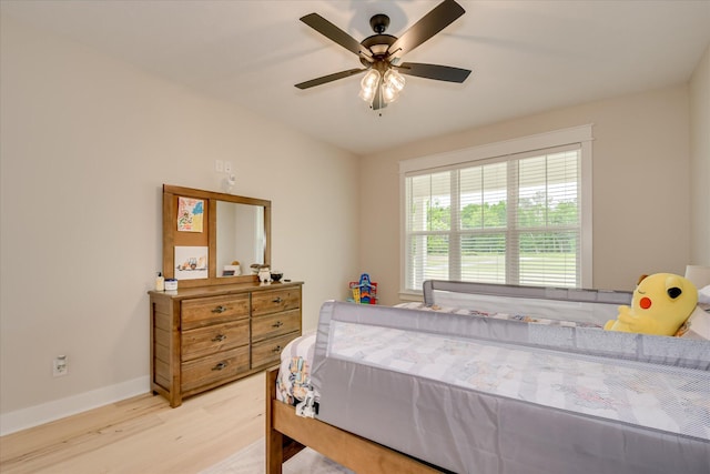 bedroom featuring baseboards, a ceiling fan, and light wood-style flooring
