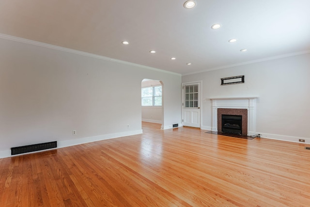 unfurnished living room with light hardwood / wood-style flooring and ornamental molding