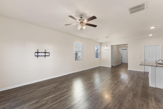 unfurnished living room featuring ceiling fan, sink, and dark wood-type flooring