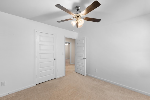 unfurnished bedroom featuring light carpet, a closet, and ceiling fan