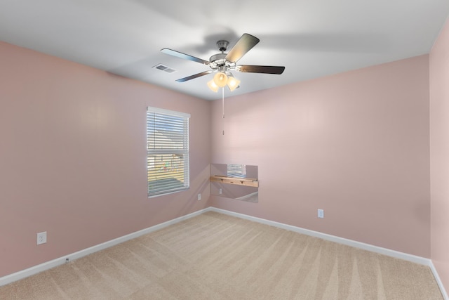 carpeted spare room featuring ceiling fan