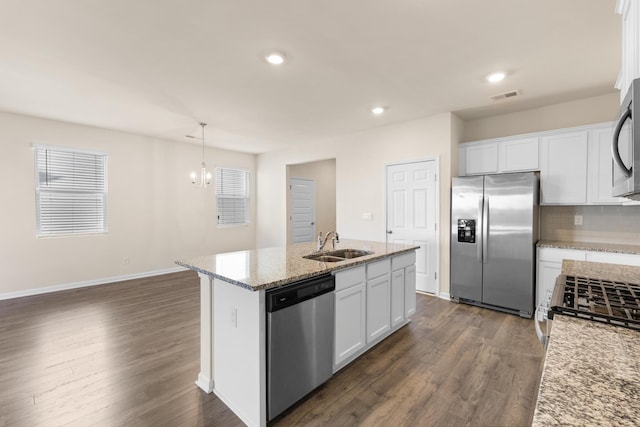 kitchen with light stone countertops, sink, stainless steel appliances, an island with sink, and white cabinets