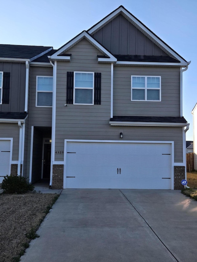 view of front of property featuring board and batten siding, driveway, and a garage