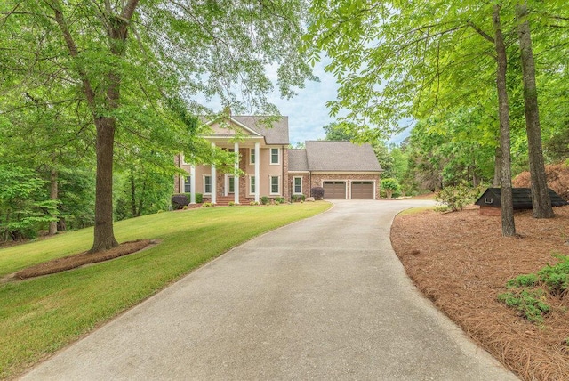 3287 Surrey Rd, Thomson, GA 30824 - greek revival house with stucco siding, driveway, a front lawn, and a garage