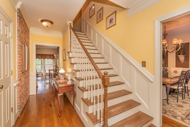 3287 Surrey Rd, Thomson, GA 30824 - stairs with crown molding, wood finished floors, and a chandelier