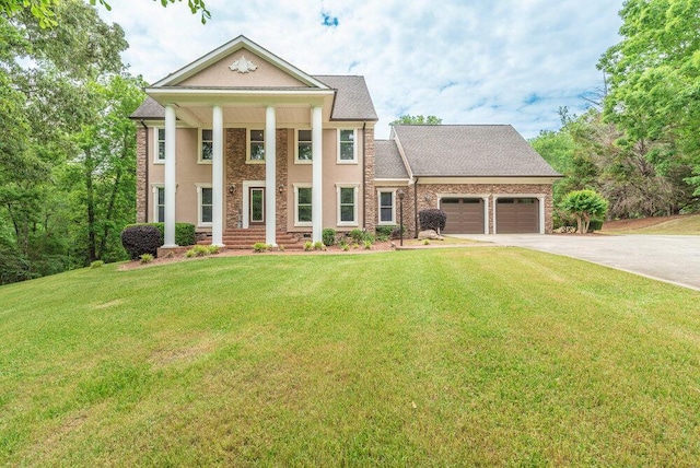 3287 Surrey Rd, Thomson, GA 30824 - neoclassical home with stucco siding, driveway, a front yard, and a garage
