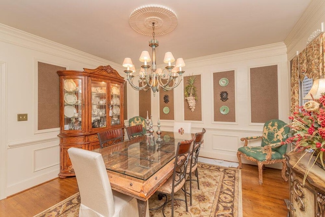 3287 Surrey Rd, Thomson, GA 30824 - dining room with ornamental molding, light wood-style flooring, a decorative wall, and a notable chandelier