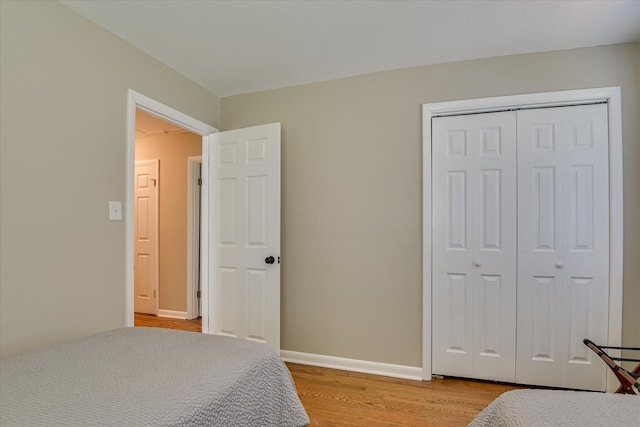 bedroom featuring light wood-style floors, a closet, and baseboards