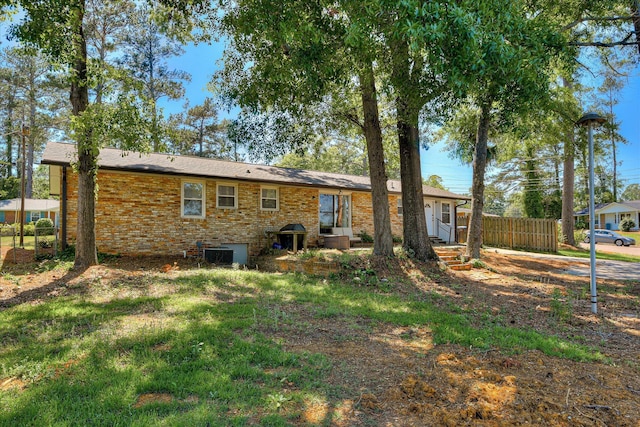 back of property with fence, brick siding, and entry steps