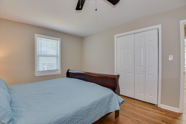 bedroom featuring wood finished floors, a closet, ceiling fan, and baseboards
