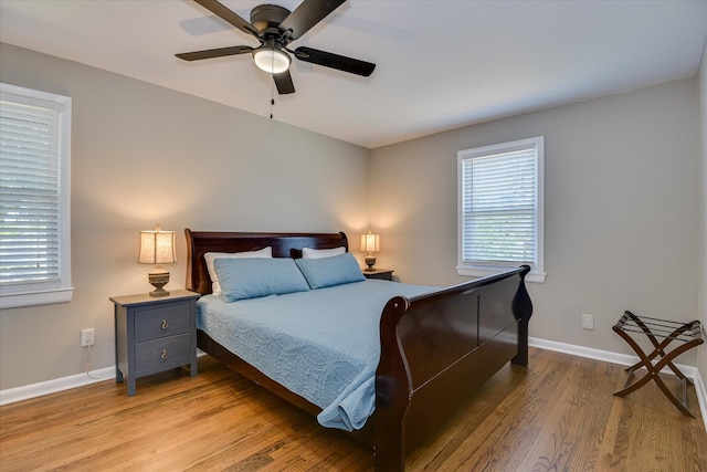 bedroom with light wood-style flooring, baseboards, and ceiling fan