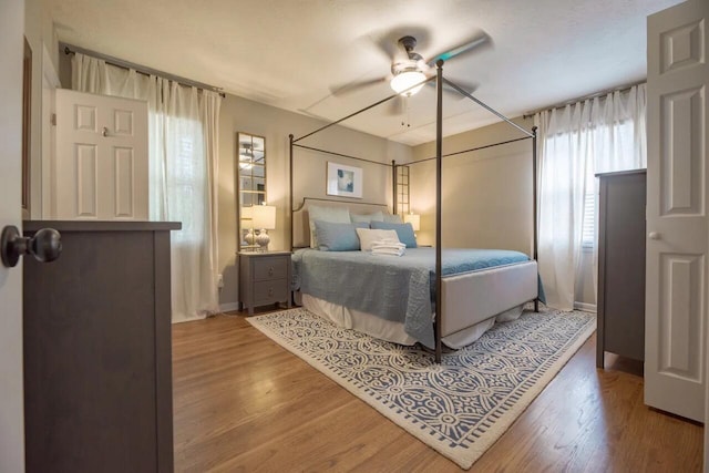 bedroom featuring wood finished floors, baseboards, and a ceiling fan