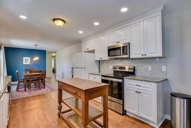kitchen with stainless steel appliances, white cabinets, light wood-style floors, and recessed lighting