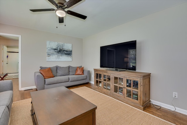 living area with ceiling fan, wood finished floors, and baseboards