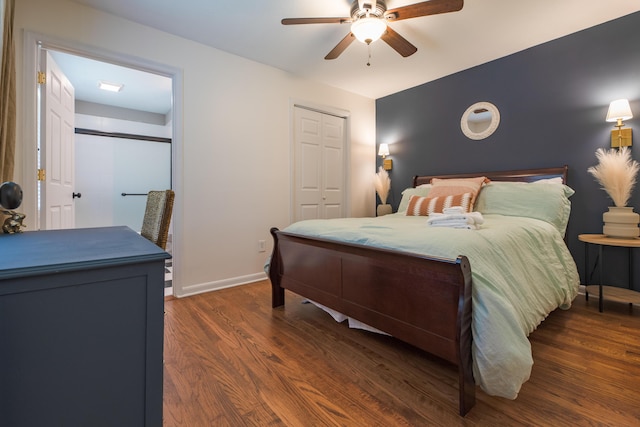 bedroom with wood finished floors, baseboards, ceiling fan, and a closet