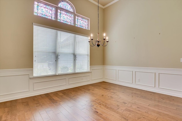 unfurnished room with ornamental molding, hardwood / wood-style flooring, and a notable chandelier