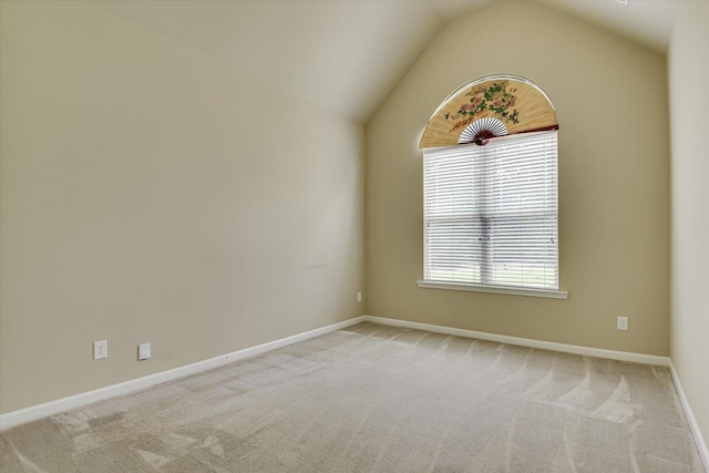 carpeted empty room featuring vaulted ceiling