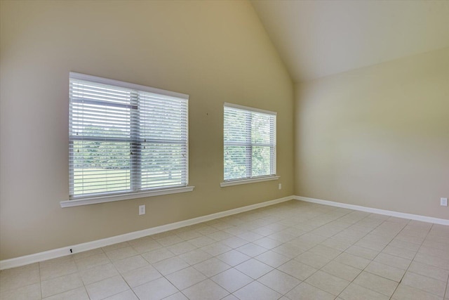 unfurnished room featuring high vaulted ceiling and light tile patterned flooring