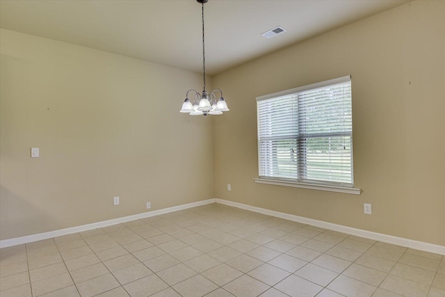 tiled empty room with a chandelier