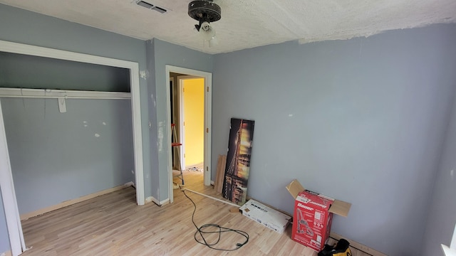 bedroom with light wood-type flooring and a closet