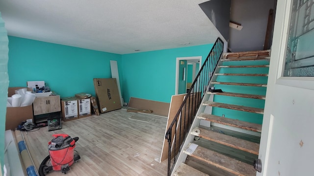 staircase with hardwood / wood-style flooring and a textured ceiling