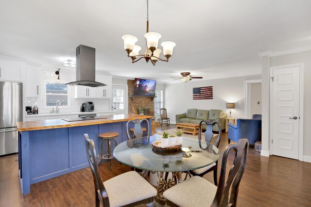2530 Springwood Dr, Augusta, GA 30904 - dining area featuring crown molding, baseboards, dark wood-style flooring, and ceiling fan with notable chandelier