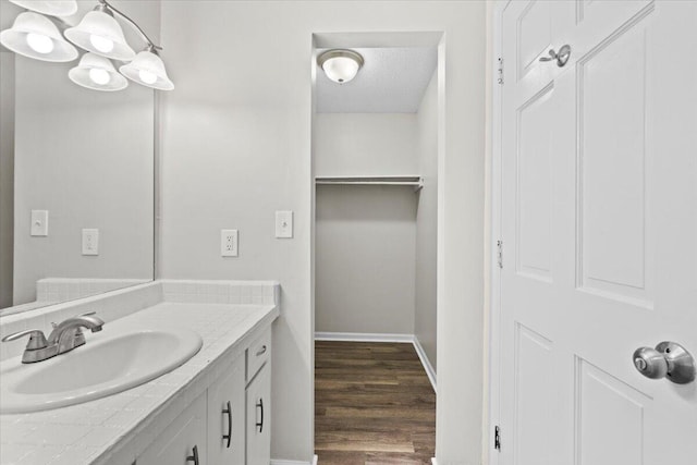 bathroom with wood-type flooring, vanity, and a textured ceiling