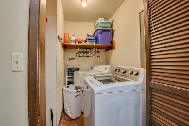 laundry area with tile patterned floors, laundry area, washer and dryer, and a textured ceiling