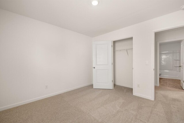 unfurnished bedroom featuring light colored carpet and a closet