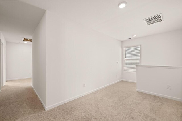 unfurnished room featuring light carpet