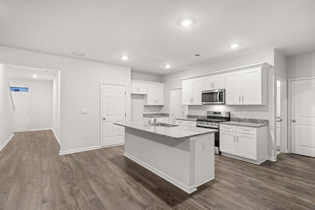 kitchen with a kitchen island with sink, dark wood-type flooring, white cabinets, and stainless steel appliances