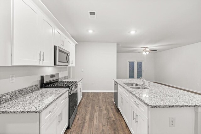 kitchen with a kitchen island with sink, dark wood-type flooring, white cabinets, ceiling fan, and appliances with stainless steel finishes