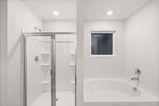 bathroom featuring shower with separate bathtub