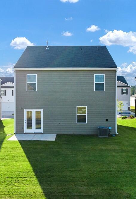 rear view of house featuring a yard and central AC