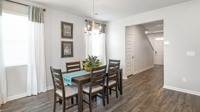 dining room featuring dark wood-type flooring and an inviting chandelier