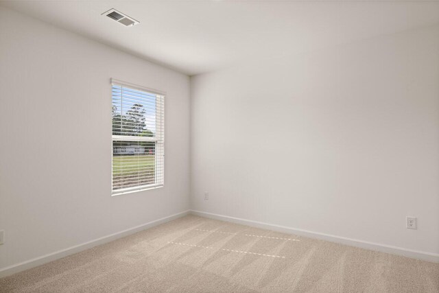 unfurnished room featuring light colored carpet