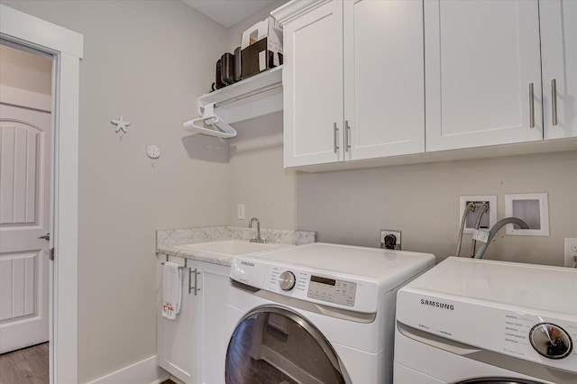 248 Amelia Dr, Mccormick, SC 29835 - washroom featuring baseboards, separate washer and dryer, a sink, wood finished floors, and cabinet space