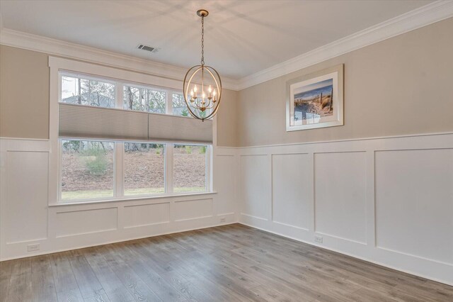 248 Amelia Dr, Mccormick, SC 29835 - unfurnished dining area featuring a decorative wall, wood finished floors, a notable chandelier, and visible vents