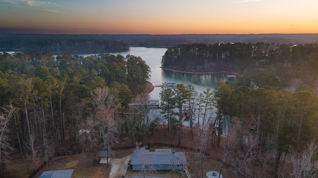 aerial view at dusk featuring a water view