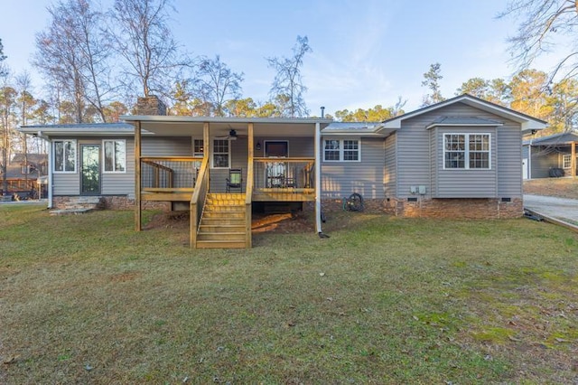 rear view of property featuring a yard and a deck