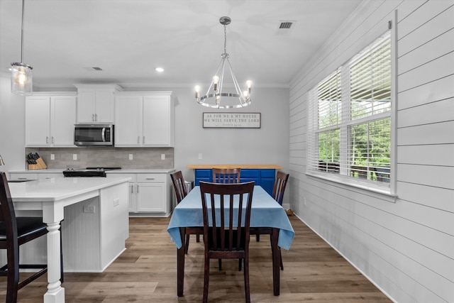 3540 Hilltop Trl, Evans, GA 30809 - kitchen with stainless steel appliances, a chandelier, crown molding, white cabinetry, and decorative backsplash