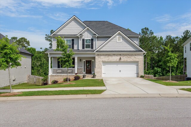 3540 Hilltop Trl, Evans, GA 30809 - craftsman-style house with covered porch, driveway, brick siding, a shingled roof, and a garage