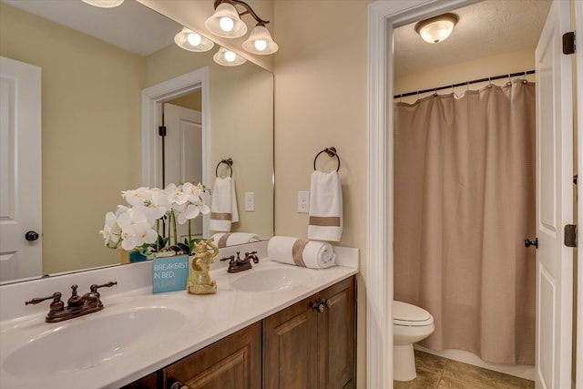 bathroom with tile patterned flooring, double vanity, and toilet