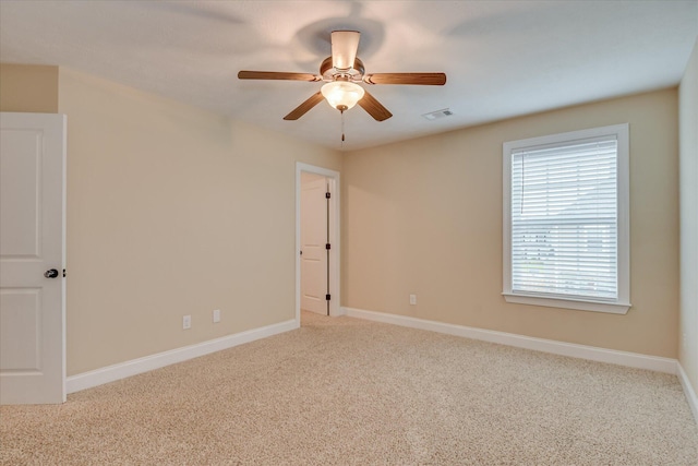 carpeted spare room with baseboards and a ceiling fan