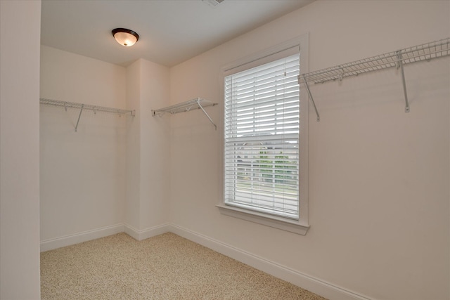 walk in closet featuring light carpet