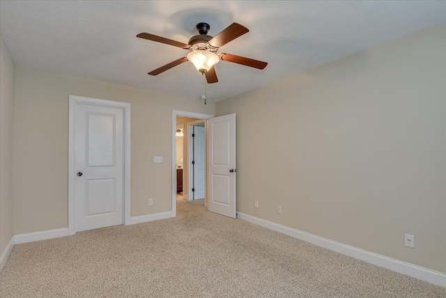 unfurnished bedroom with light colored carpet, baseboards, and a ceiling fan