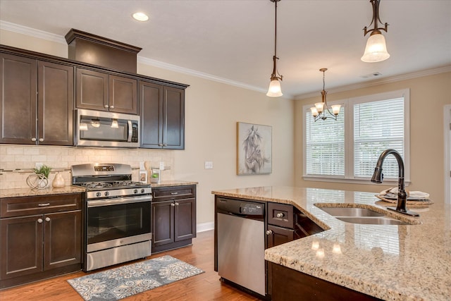 kitchen featuring stainless steel appliances, a sink, dark brown cabinets, decorative backsplash, and crown molding