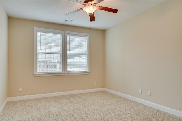 carpeted spare room with baseboards and a ceiling fan