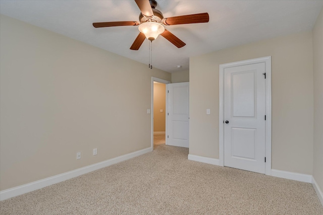 unfurnished bedroom with light colored carpet, baseboards, and ceiling fan